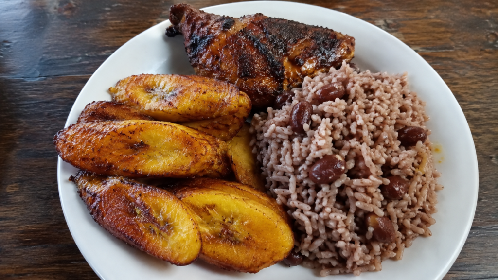 Fried plantains served with grilled chicken and rice