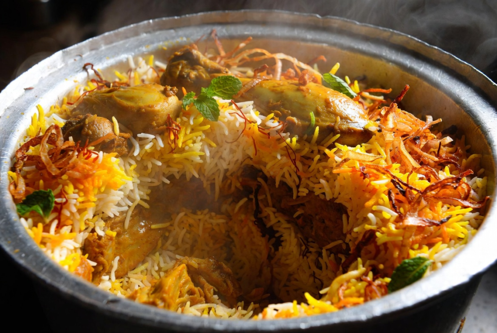 Layering healthy chicken biryani with rice herbs and chicken