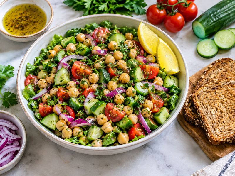 chickpea salad with cucumber tomatoes onions leafy greens and lemon