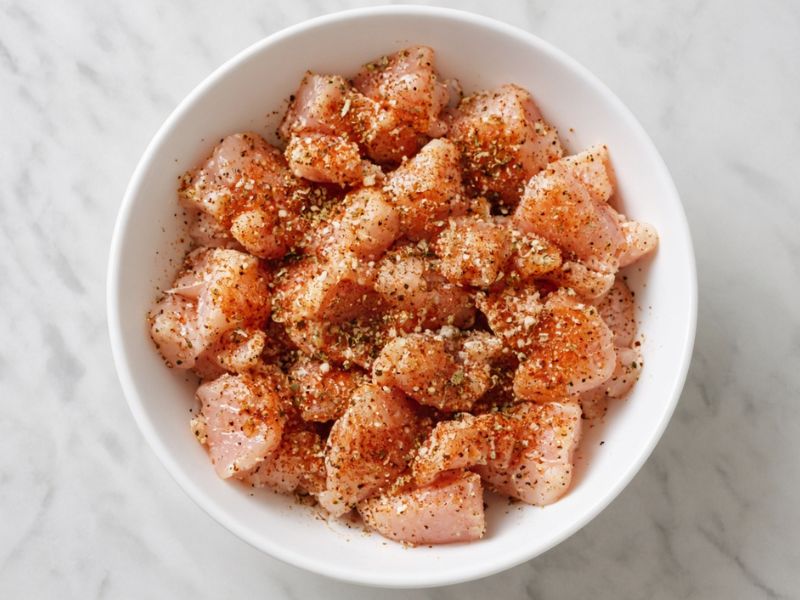 Seasoned chicken pieces ready for cooking