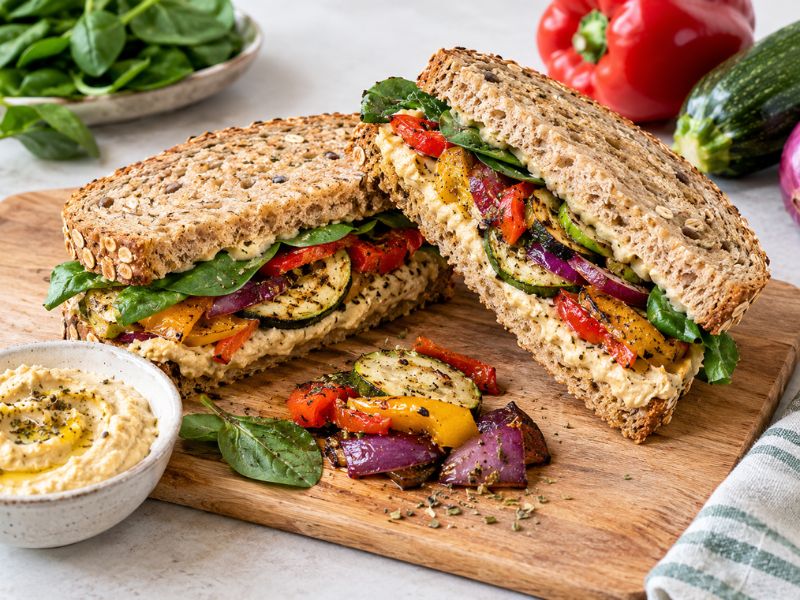 hummus roasted vegetable sandwich with peppers zucchini spinach and whole grain bread