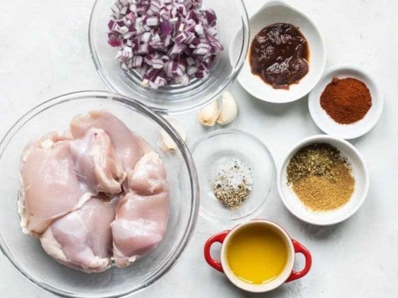 Raw chicken thighs with olive oil, lime, garlic, and assorted spices