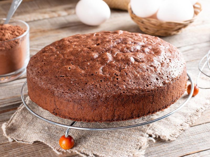 Freshly baked chocolate cake cooling on a wire rack before frosting