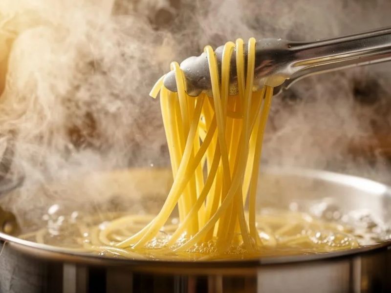Spaghetti cooking in a pot of boiling water
