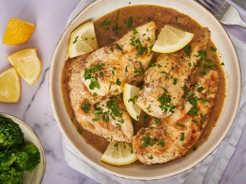 Lemon garlic chicken breasts with fresh lemon slices and parsley