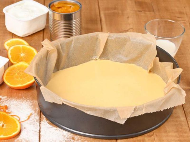 Lemon yogurt cake batter spread evenly in a prepared round baking pan