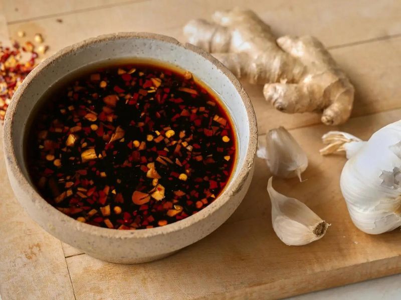Sweet chilli sauce, soy sauce, lime juice, minced garlic, and grated ginger in bowls