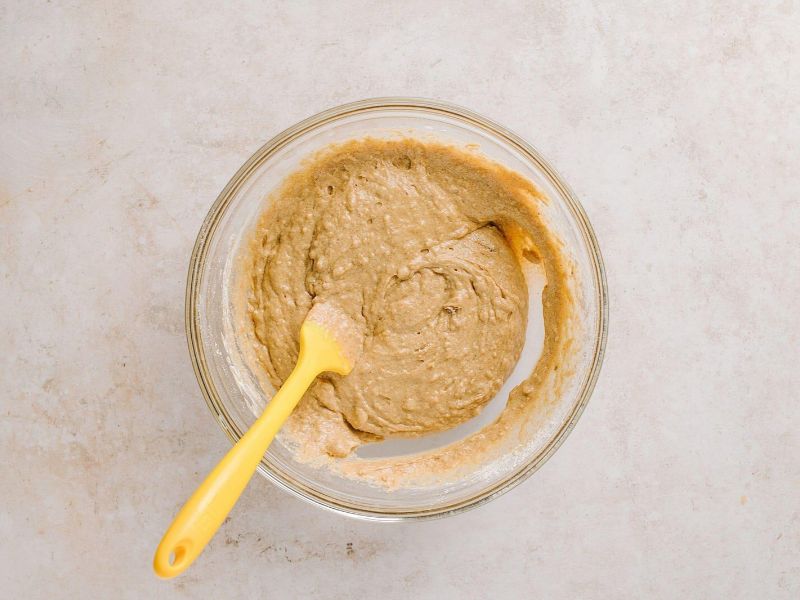 Thick applesauce cake batter gently mixed with cinnamon and wet ingredients