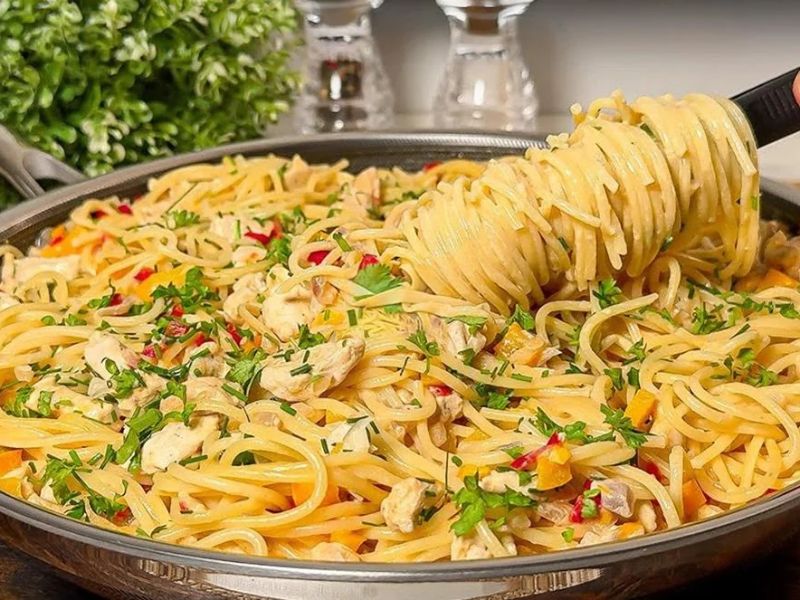 Spaghetti tossed with shredded chicken, vegetables, and creamy cheddar sauce