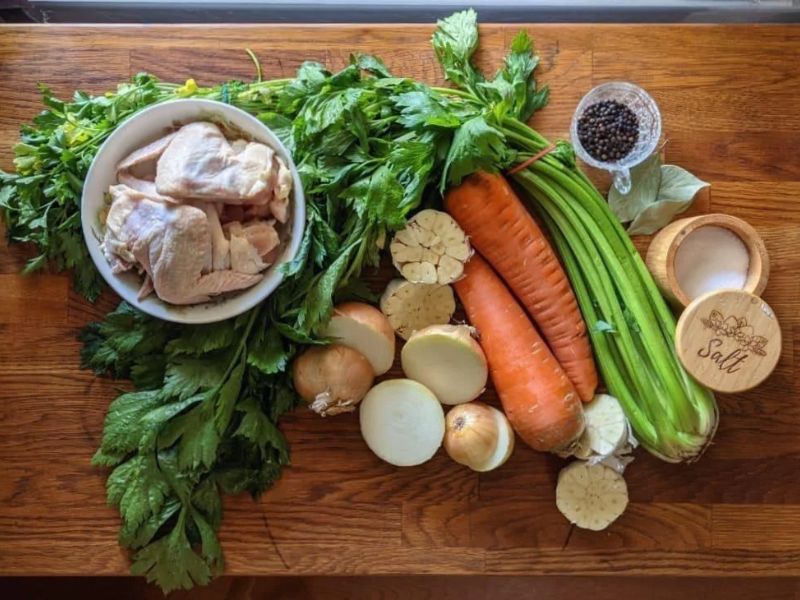 Prepared chicken bones, chopped vegetables, garlic, and herbs for homemade stock