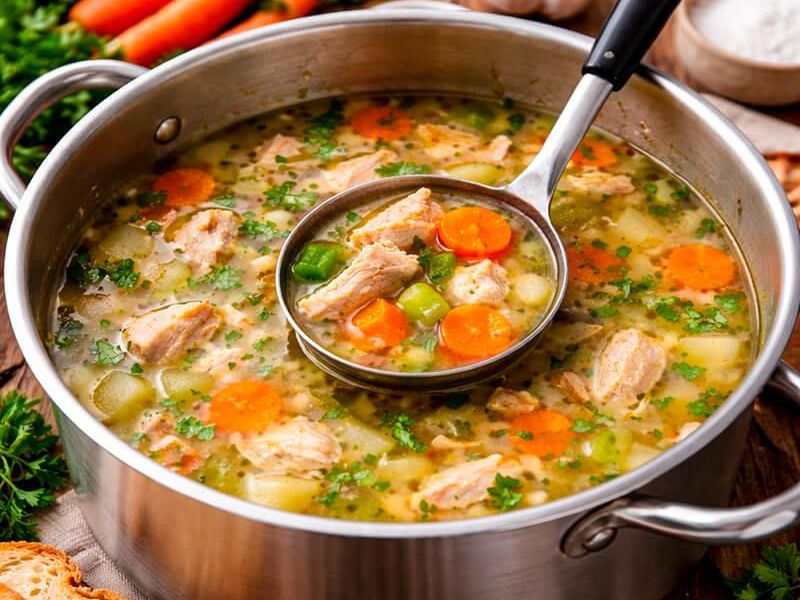 Chicken and vegetables simmering in broth for chicken vegetable soup